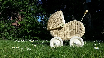 Geflochtener Kinderwagen auf einer grünen Wiese © pixabay.com