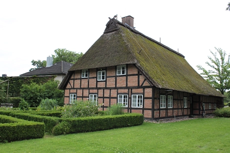 Das Heimathaus in Fintel als Außenansicht im Sommer. Es ist ein reetgedecktes Fachwerkhaus.