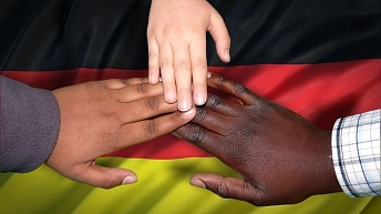 Sich reichende Hände verschiedener Personen, im Hintergrund ist die Deutschlandflagge © pixabay.com